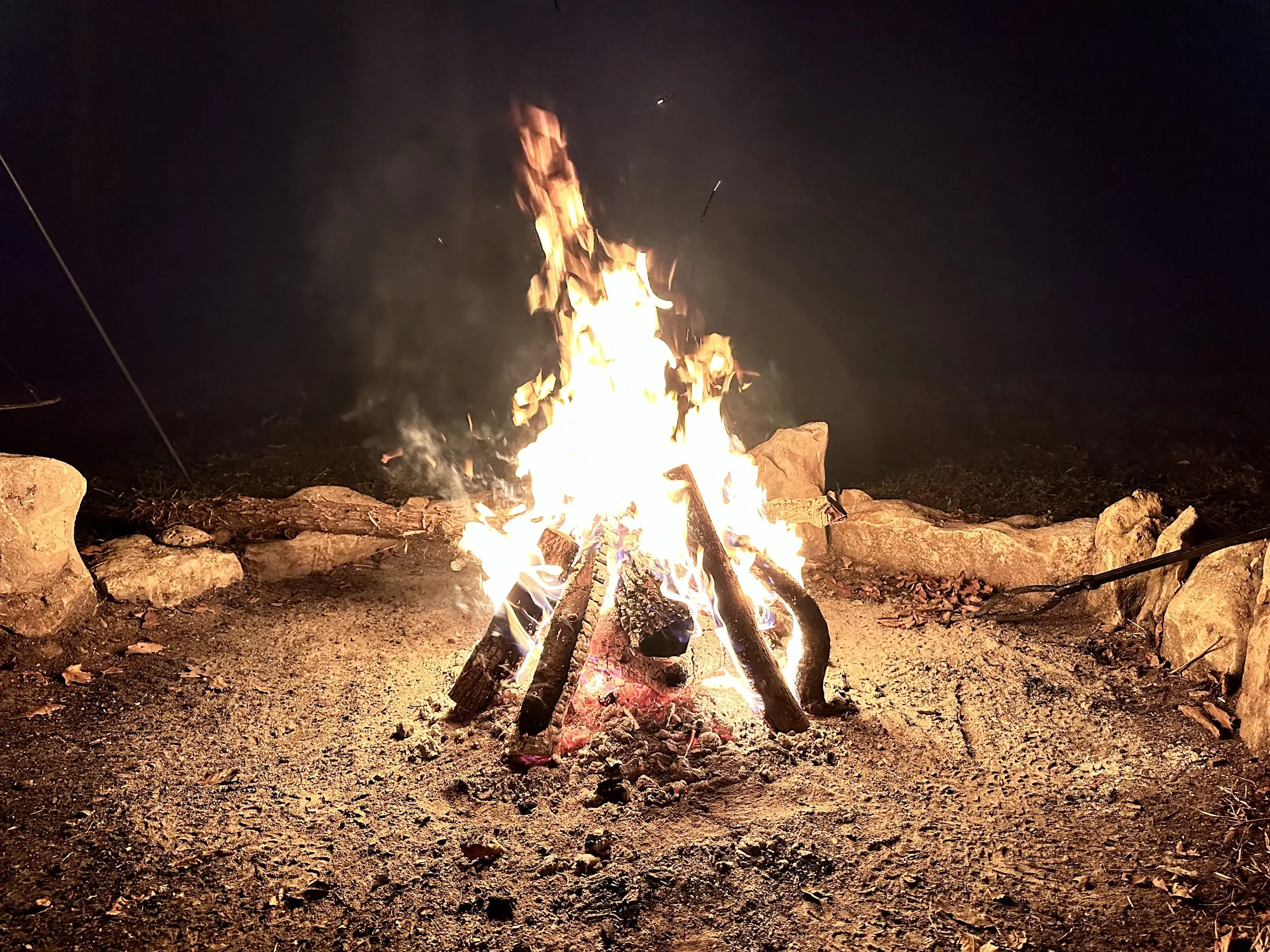 A roaring campfire burning bright at night